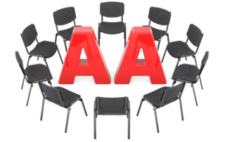 Black chairs arraanged in a circle with red letters in the center AA